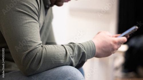 Sitting man playing with phone