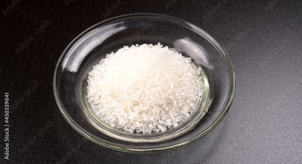 Sugar in glass bowl on wooden background. Sugar in glass bowl on wooden background.