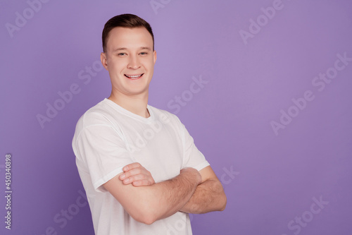 Portrait of positive confident handsome strong guy crossed arms on violet background