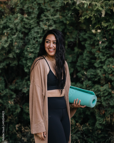 Young adult Filipino woman practicing yoga outdoors at home