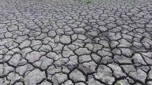 Flying over the desert from a bird's eye view of weed on the cracked crust of the soil from drought. Dried crust. A desert without water. A barren field in hot weather.