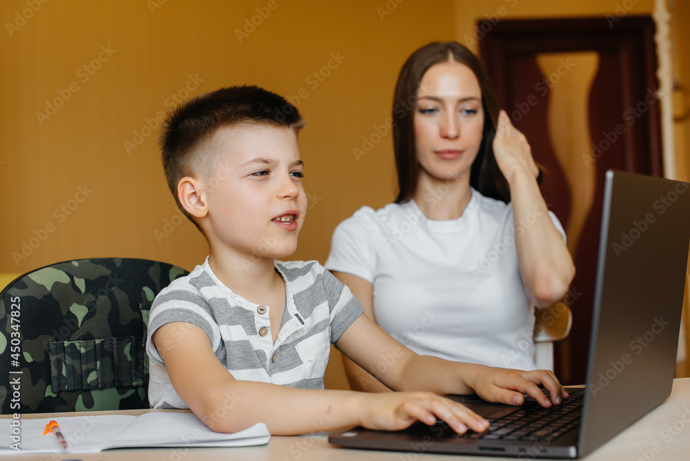 A mother and her child are engaged in distance learning at home in front of the computer. Stay at home, training A mother and her child are engaged in distance learning at home in front of the computer. Stay at home, training