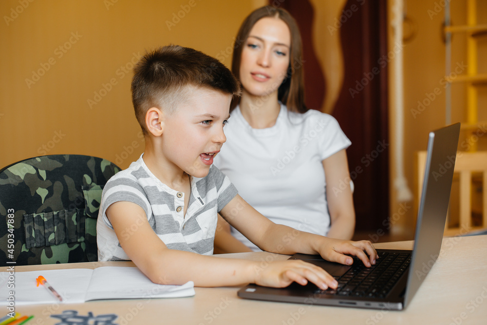 A mother and her child are engaged in distance learning at home in front of the computer. Stay at home, training A mother and her child are engaged in distance learning at home in front of the computer. Stay at home, training