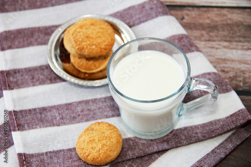 white milk in a glass mug and shortbread cookies