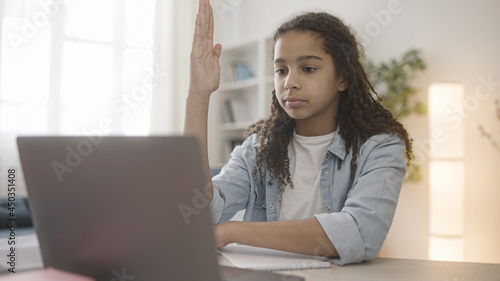 Black teen girl answering teacher while having online lesson, distance learning