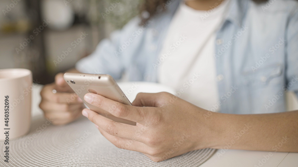 Black teen girl texting on smartphone during breakfast, gadget addiction