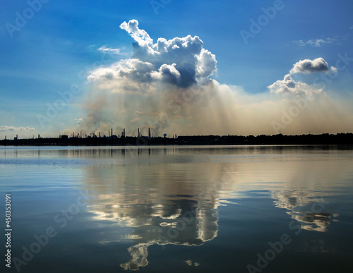 horrible cloud of smog from a steel plant is reflected in water