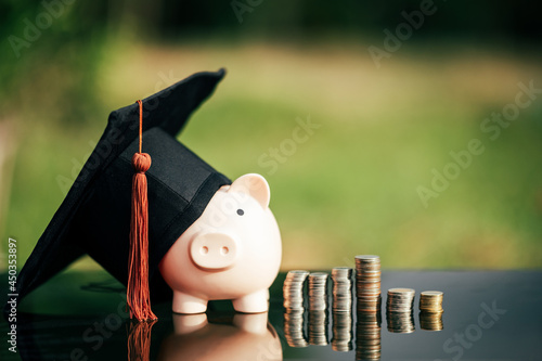 piggy bank With Graduation Cap on black glass floor,Money saving concept.. photo