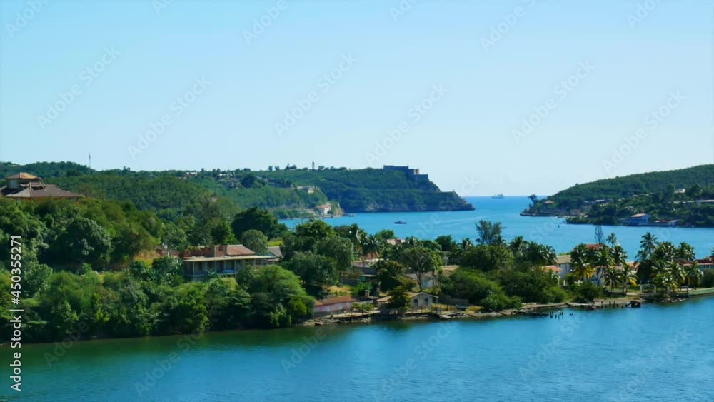 View of the entrance to the Santiago de Cuba bay. Some colorful buildings and coral beach View of the entrance to the Santiago de Cuba bay. Some colorful buildings and coral beach