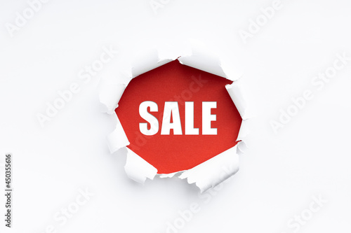 torn paper revealing the word sale photo