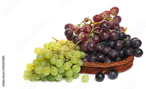 Grapes in wooden wicker basket, isolated on white background