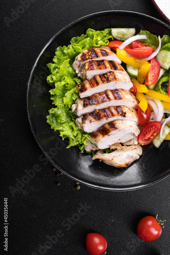 salad grilled chicken breast vegetables tomato, cucumber, onion, pepper outdoor meal snack on the table copy space food background rustic. top view keto or paleo diet