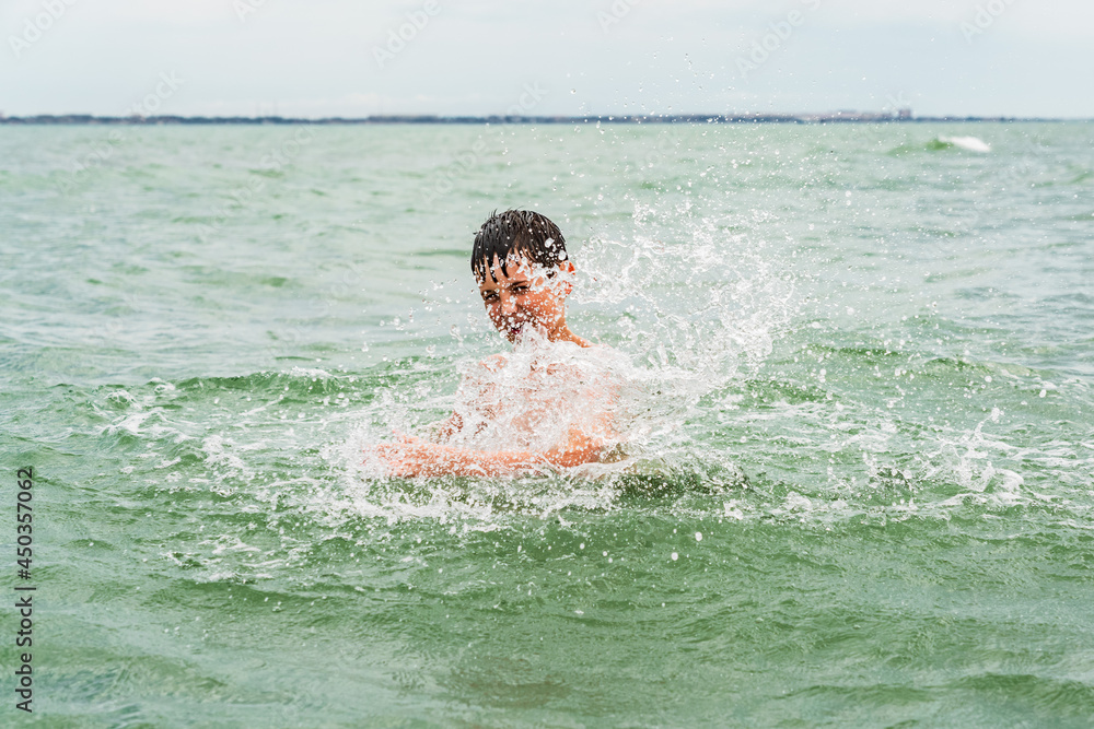 Happy child splashing in the sea
