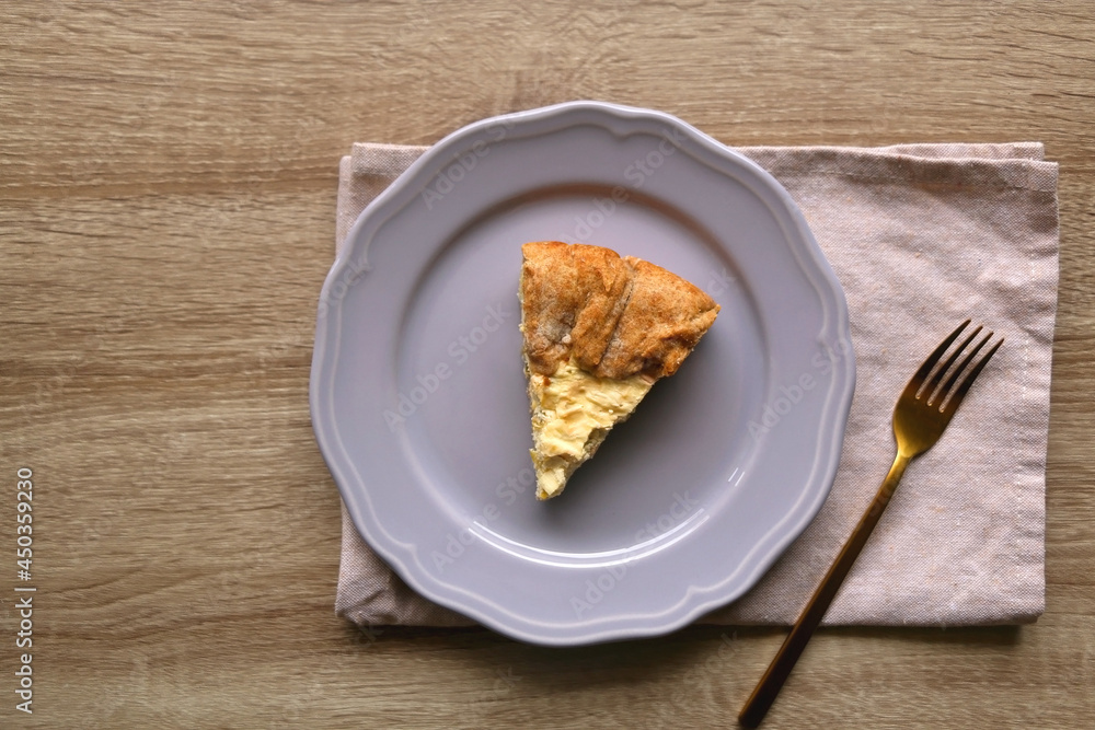 Slice of cheese and leek quiche on wooden table. Flat lay. Slice of cheese and leek quiche on wooden table. Flat lay.