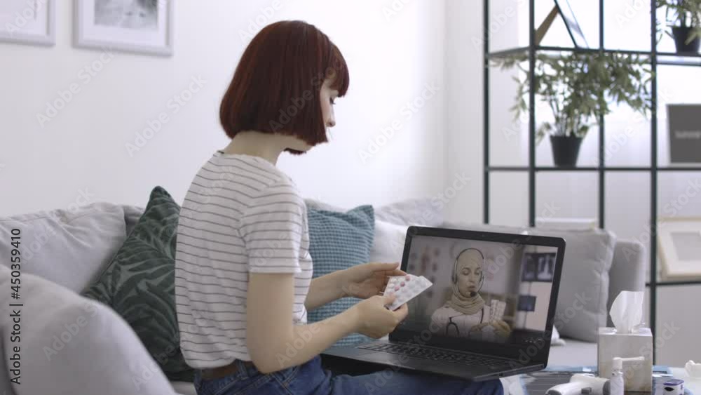 Medicine, technology and healthcare concept. Young woman patient, sitting on sofa at home with pills in hand, having video chat with female doctor on laptop pc and consulting about treatment. Medicine, technology and healthcare concept. Young woman patient, sitting on sofa at home with pills in hand, having video chat with female doctor on laptop pc and consulting about treatment.