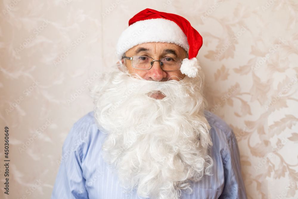 portrait of senior man in santa hat looking at camera portrait of senior man in santa hat looking at camera