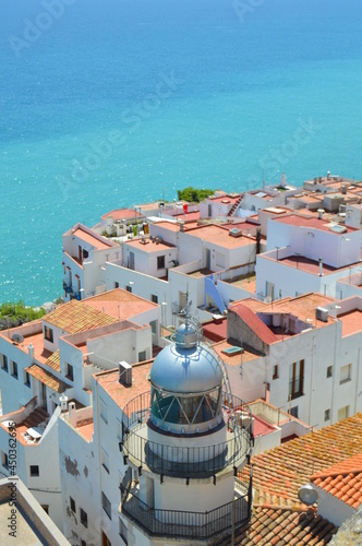 Lighthouse between white houses in the old Peñiscola town and the blue sea
