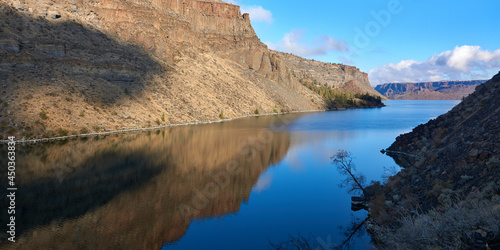 Reflection of the blue sky in the water of Deschutes River in the rocky canyon in central Oregon.