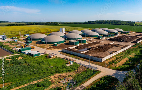 Biogas station at the green large field. Distillation process is used to produce bio gas at station. View from above photo