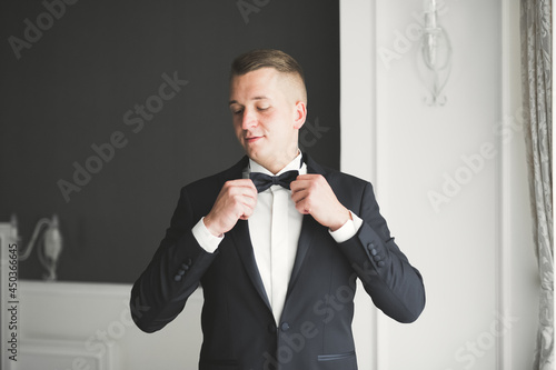 Grooms morning preparation. Handsome man getting dressed and preparing for the wedding photo