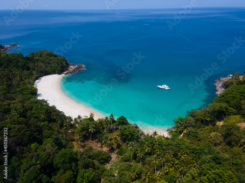 Aerial view top-down of Drone camera over white beach sand and sew water clear. Nature video view of beautiful tropical beach and sea in sunny day. Palm tree at beach. At Phuket, Thailand.