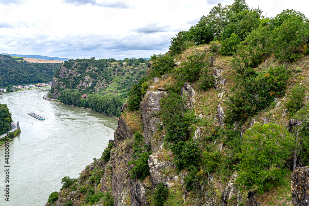 Rock formations on the edge of a cliff above a river in West Germany.