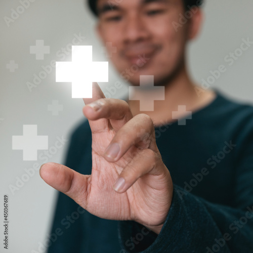Handsome man touching plus sign icon means to offer positive thing. like benefits, personal development, social network concept