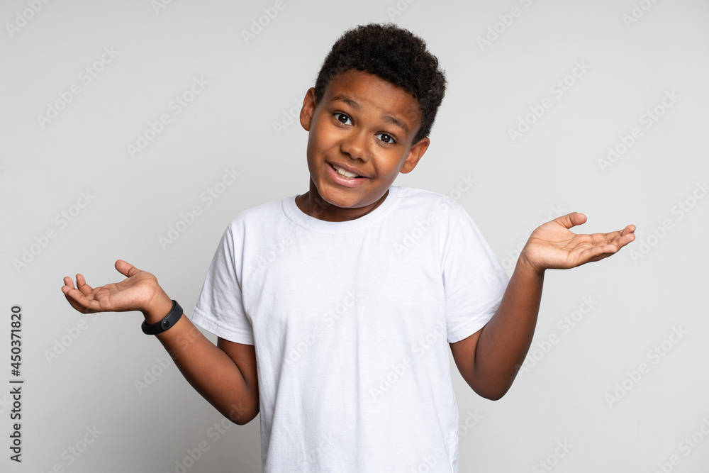 Misunderstanding. Portrait of little boy raising hands and asking question, while gesturing in bewilderment. Indoor studio shot, isolated Misunderstanding. Portrait of little boy raising hands and asking question, while gesturing in bewilderment. Indoor studio shot, isolated