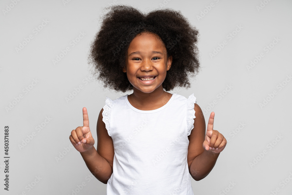 Wow, look up. Portrait of amazed little girl pointing up to empty place on white background, expressing positivity and showing copy space for advertisement. Indoor studio shot Wow, look up. Portrait of amazed little girl pointing up to empty place on white background, expressing positivity and showing copy space for advertisement. Indoor studio shot