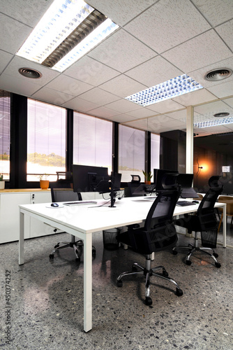 modern open space office with computer monitors on white desks