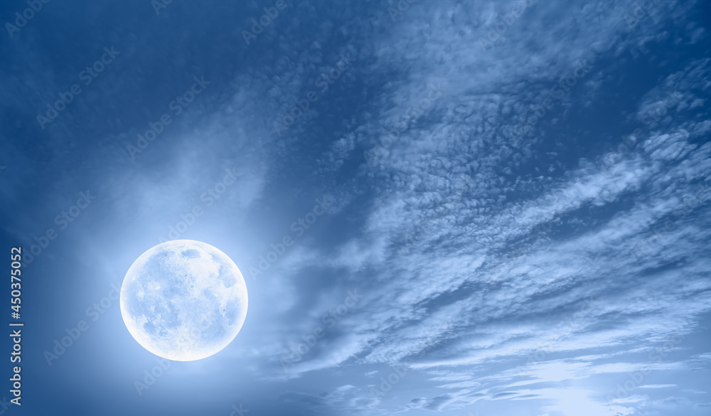 Night sky with full bright moon in the clouds, blue sea in the foreground Night sky with full bright moon in the clouds, blue sea in the foreground