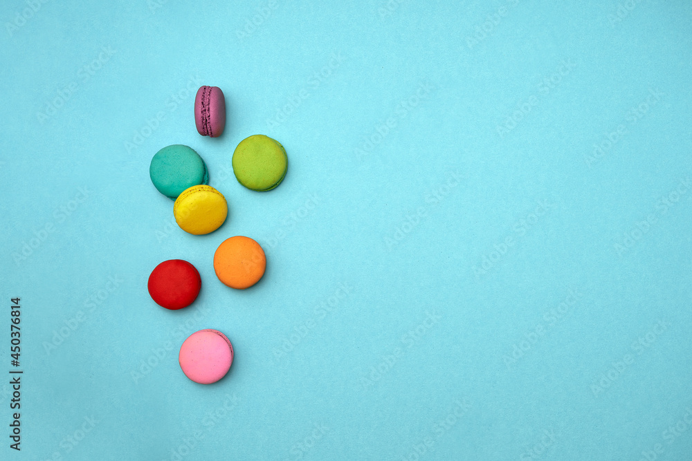 top down composition multicolored sweet dessert macaroni cakes are randomly scattered isolated on a pale blue background with space for text. concept of diet, mother day, delicious junk food top down composition multicolored sweet dessert macaroni cakes are randomly scattered isolated on a pale blue background with space for text. concept of diet, mother day, delicious junk food