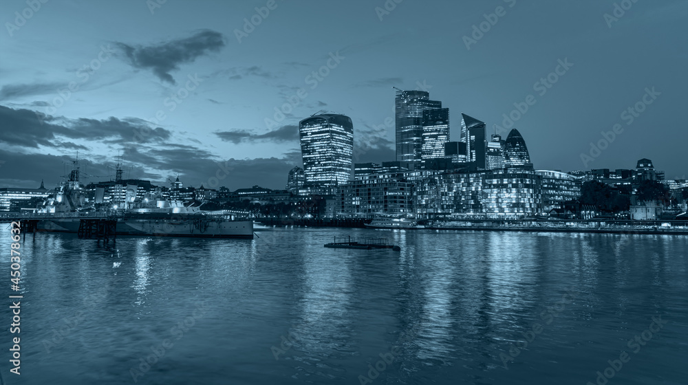 Panorama of the modern skyline on Thames river at twilight blue hour - London, United Kingdom -                Night view of the downtown City of London