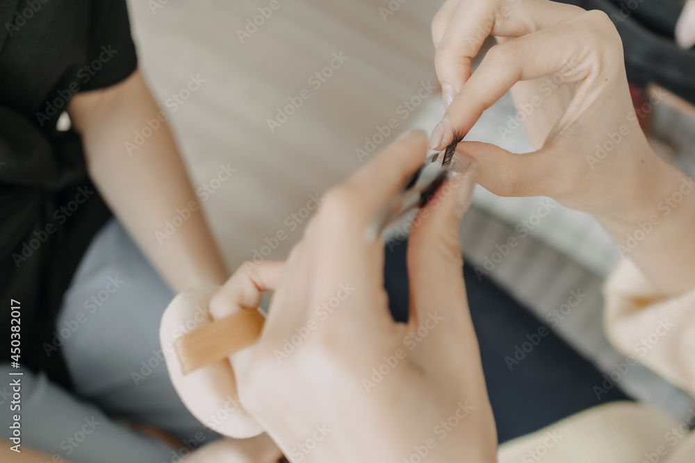 Asian woman makeup artist is at work and wearing makeup on her model. Asian woman makeup artist is at work and wearing makeup on her model.