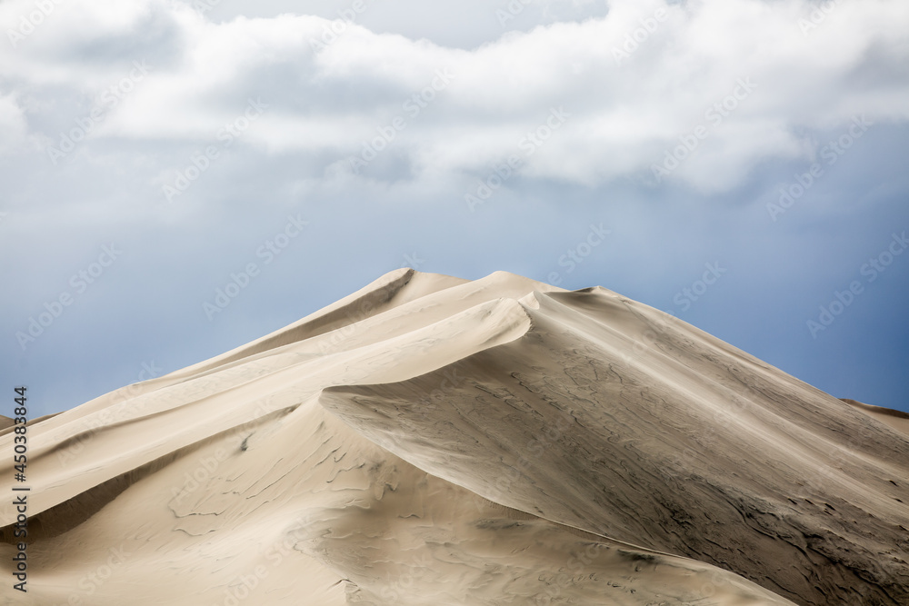 Fototapeta premium moody lines on sand dune with clouds