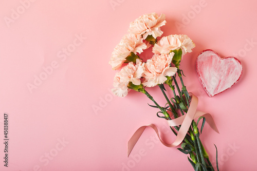 Fototapeta Naklejka Na Ścianę i Meble -  Bouquet of pink carnations. Design concept of holiday greeting with carnation bouquet on pink table background