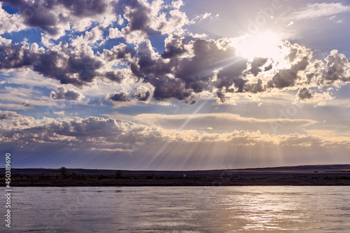 dramatic sunrise over a steppe river with a calm current