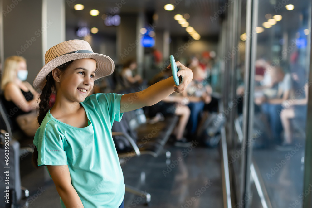 tourism, vacation, childhood and transportation concept - smiling little girl with travel bag, ticket and passport over airport background.