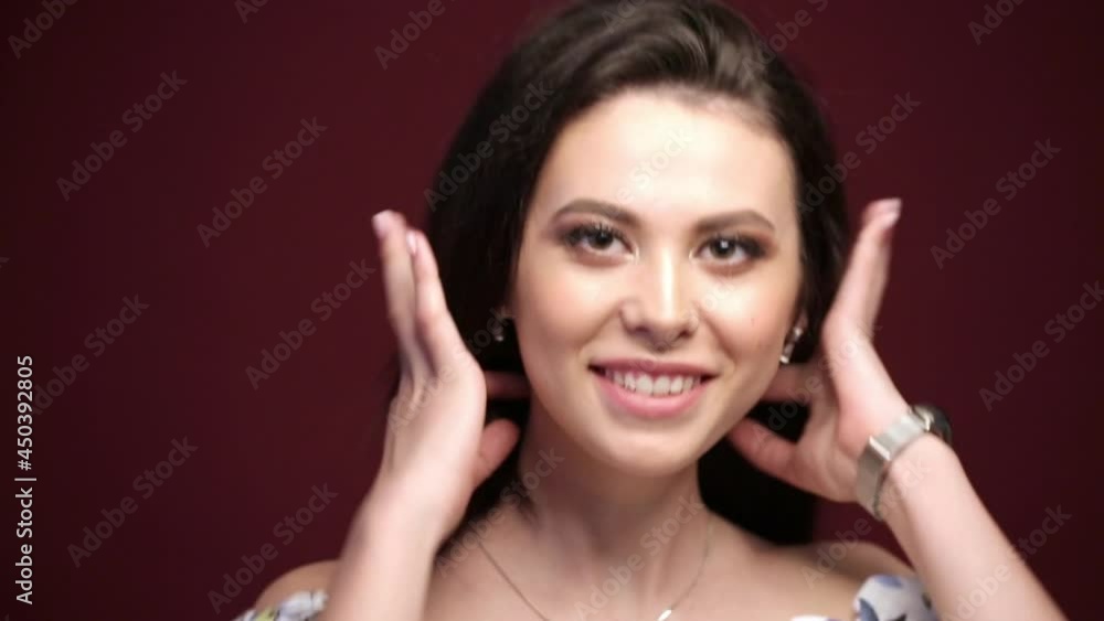 Healthy, clean, perfect facial skin. Beauty portrait of a young female model posing with caucasian appearance. Work in a photo studio on a red background. Beautiful brown eyes. Healthy, clean, perfect facial skin. Beauty portrait of a young female model posing with caucasian appearance. Work in a photo studio on a red background. Beautiful brown eyes.