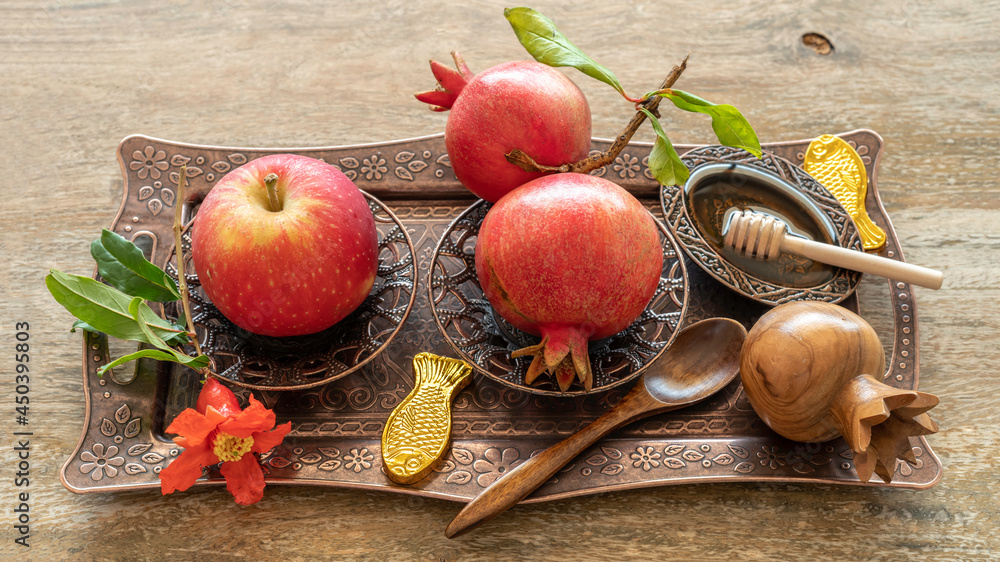 Red apple, pomegranate fruits, fish shaped candies, fresh honey for Jewish holiday Rosh Hashanah on copper tray. Red apple, pomegranate fruits, fish shaped candies, fresh honey for Jewish holiday Rosh Hashanah on copper tray.