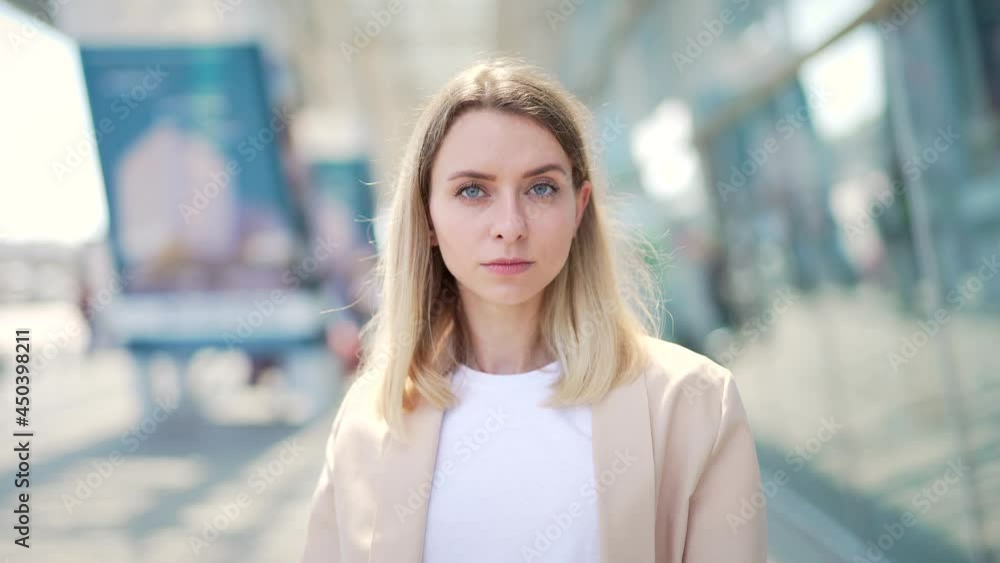 portrait confident serious young woman outdoors looking at camera with blurred urban city background. Angry strong female blonde activist. protest against. disagrees with facial expressions close up portrait confident serious young woman outdoors looking at camera with blurred urban city background. Angry strong female blonde activist. protest against. disagrees with facial expressions close up