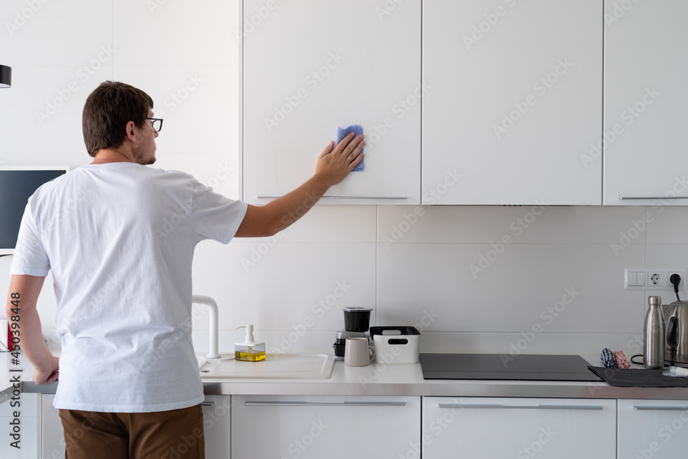 Man cleaning the kitchen surfaces