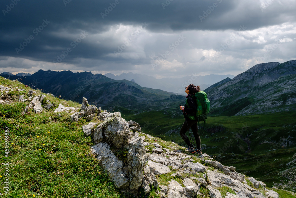 hiker under a stormy sky, col de Anéou, Ayous lakes tour, Pyrenees National Park, Pyrenees Atlantiques, France