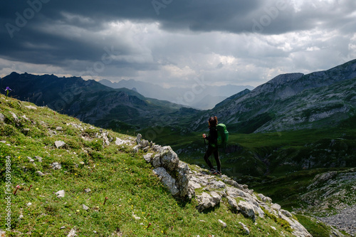 hiker under a stormy sky, col de Anéou, Ayous lakes tour, Pyrenees National Park, Pyrenees Atlantiques, France