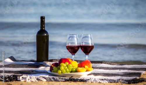 Fototapeta Naklejka Na Ścianę i Meble -  Picnic blanket, wine, fruit, beautiful sea beach. Selective focus