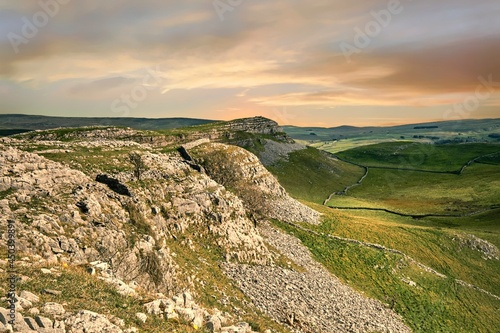 Soft pink light over the limestone features of Smearsett Scar near Stainforth in the Yorkshire Dales, shot in landscape