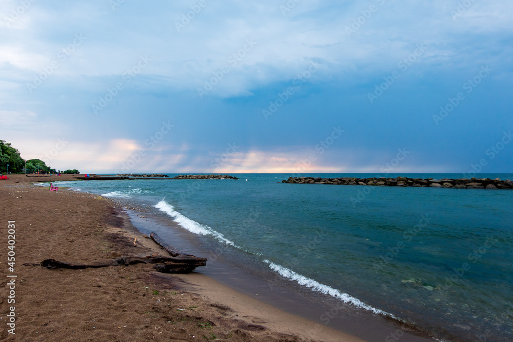 Fototapeta premium Looking out on Lake Ontario from an empty beach after a morning rain storm has pasted. Shot in Toronto's Beaches neighbourhood shot in mid June