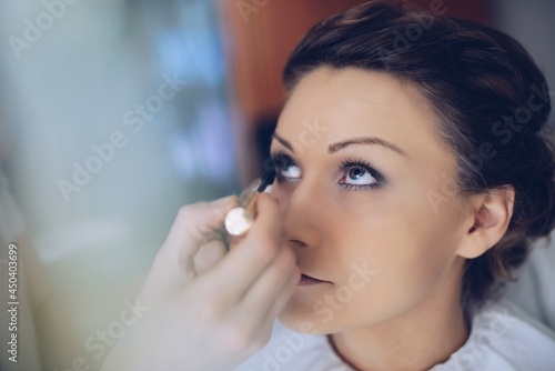 Woman applying make up for a bride in her wedding day. Wedding day moment.