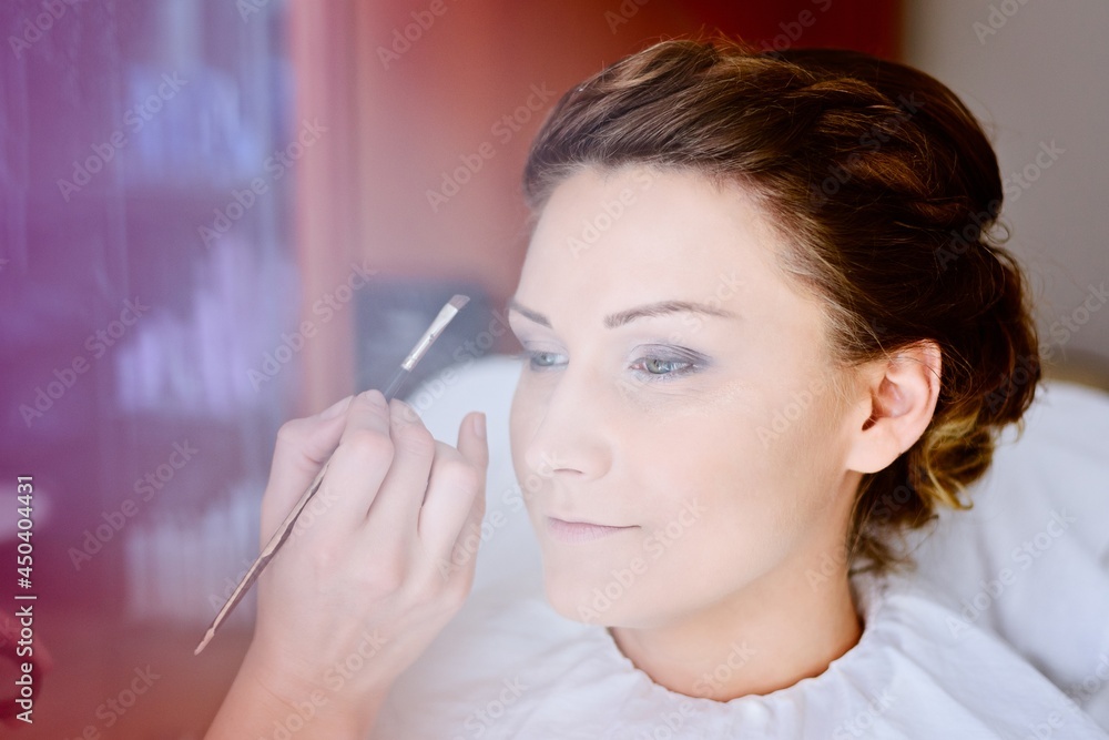 Makeup artist preparing bride before the wedding in a morning. Wedding day.