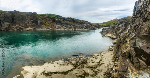 Come clear transparent river waters between rocky banks in Iceland. 